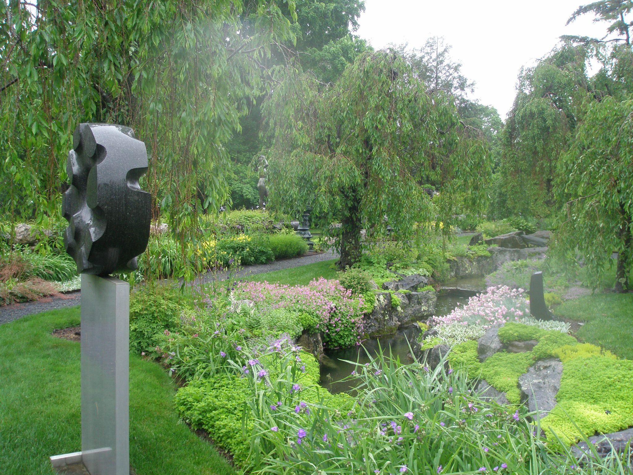 ..rain, Rain, RAIN...in the Brook Garden. Isamu Noguchi's BLACK SUN (1960-63) is mounted on a slim, gray pedestal