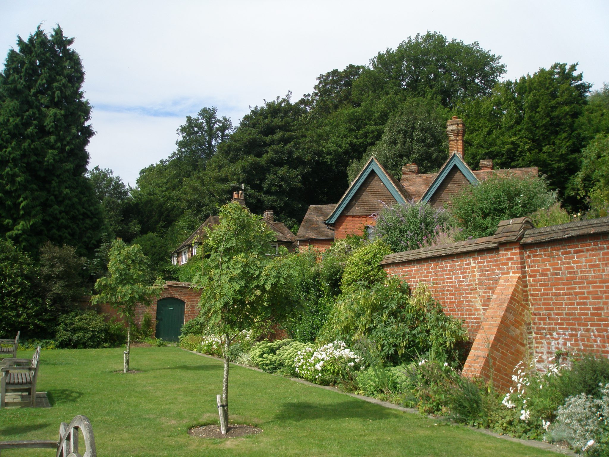 Buttressed brick walls enclose the Orchard. A row of Kentish-tile-hung cottages is behind the wall. Clementine referred to these as "her village."