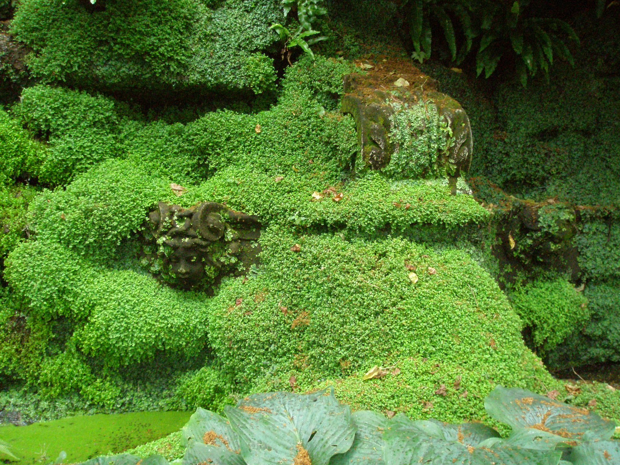 Statues in the Grottoes are nearly swallowed up by greenery.