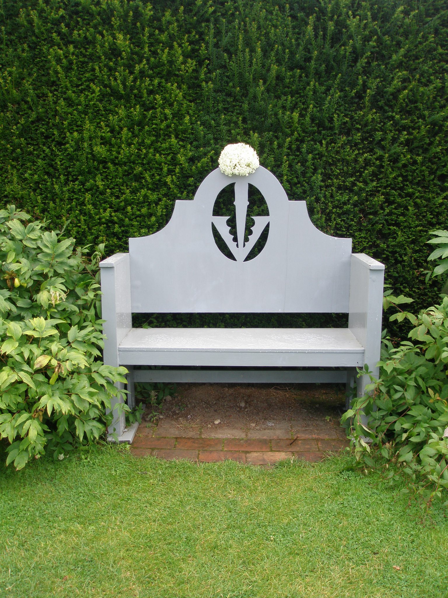 A bench in the Grey & White Garden, crowned with the Sidney Coat of Arms...and a hydrangea corsage.
