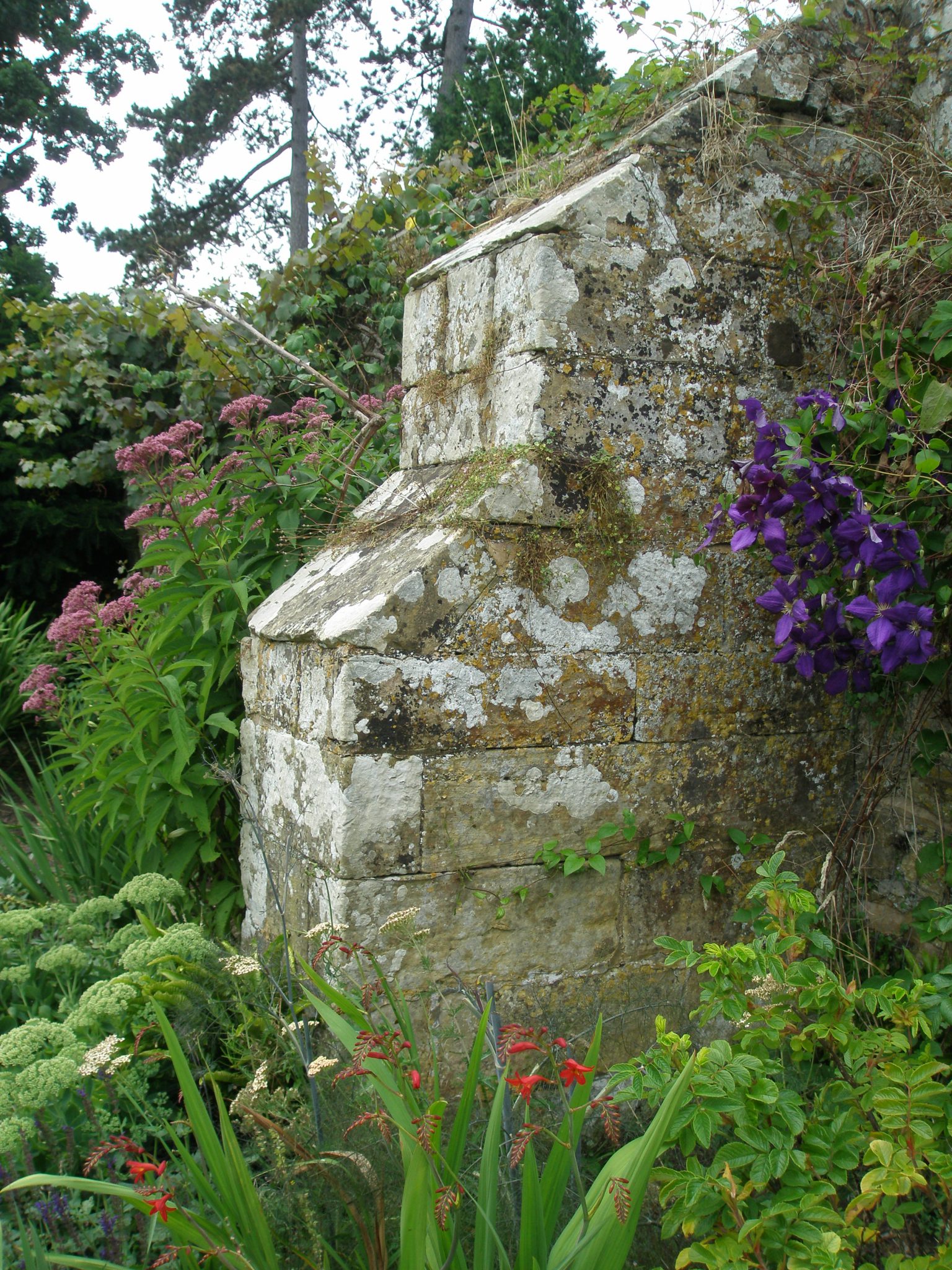 Lichen-covered stone, of a garden wall's buttress.