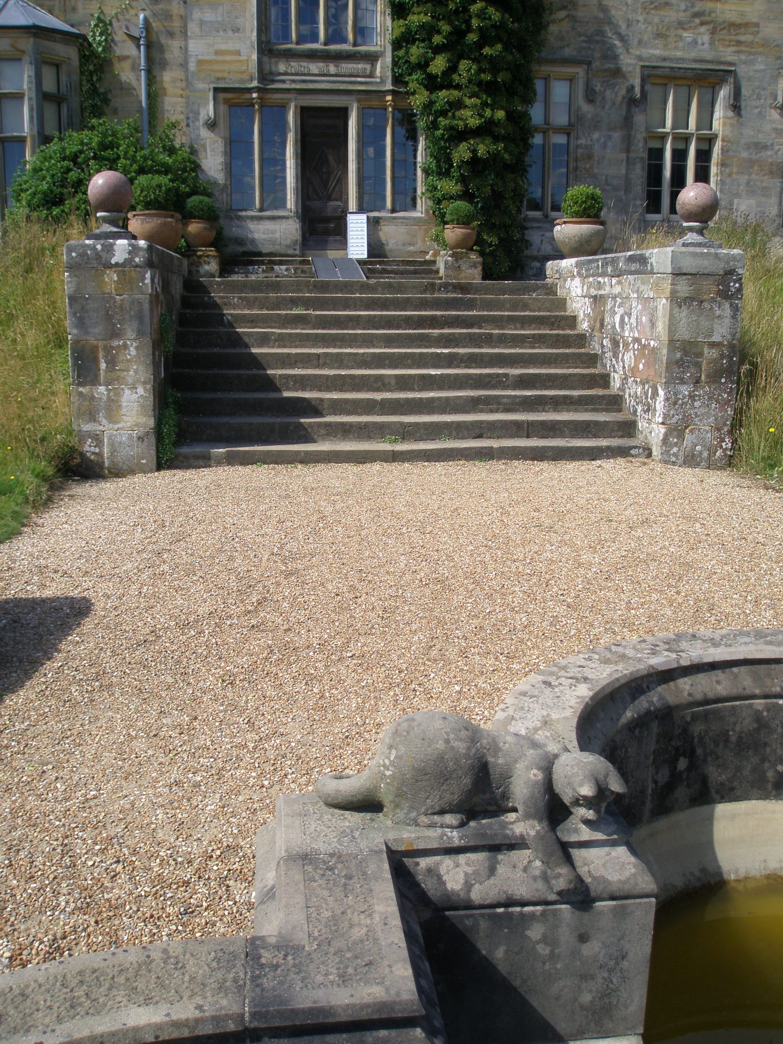 A Stone Kitten, on the Garden Front Terrace, with a view back toward the door to the Garden Lobby of the New House.