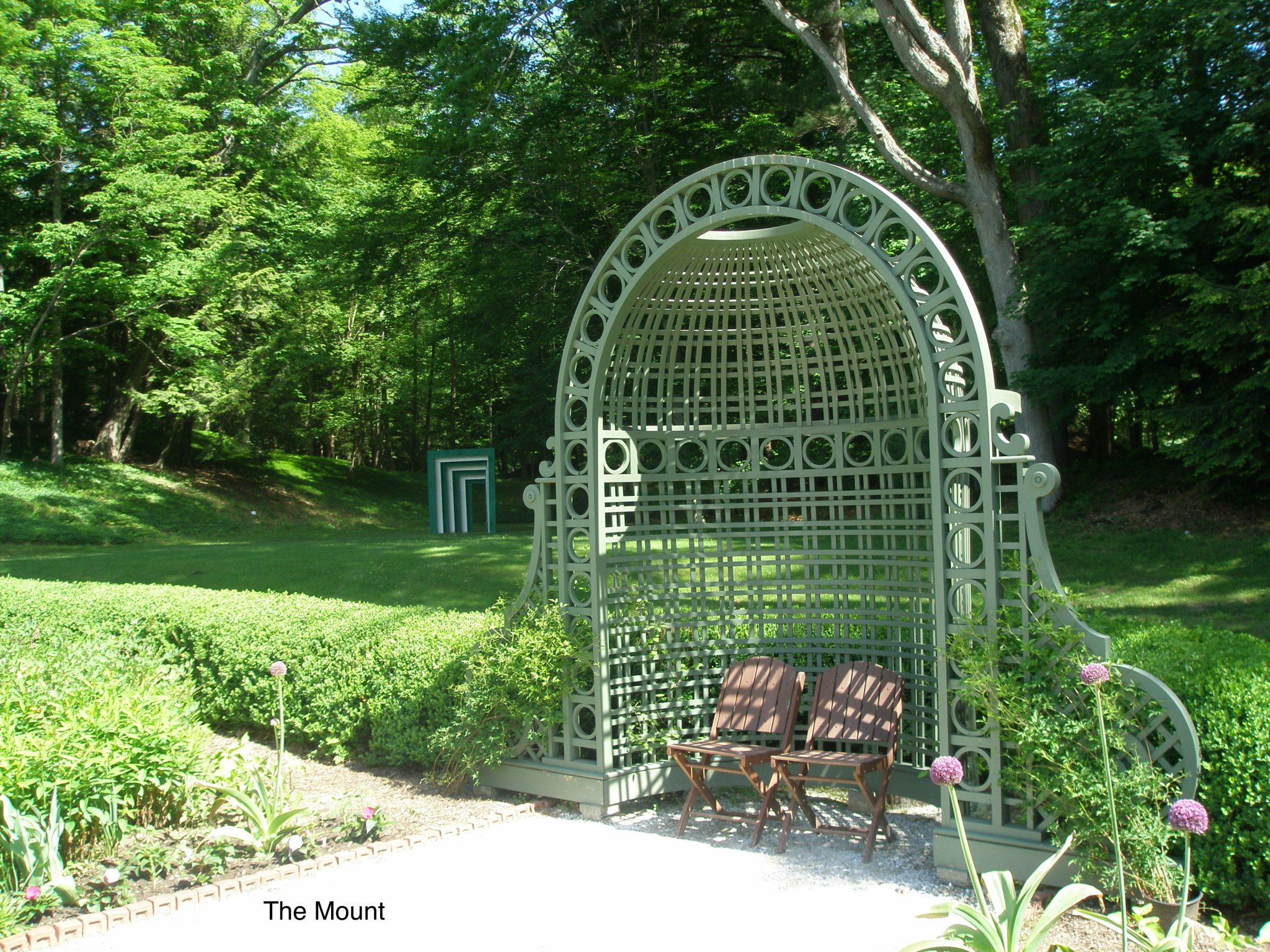 Here's a nice transition, from new to old. In the background: a contemporary, green and white archway. In the foreground: the Flower Garden's original Trellis Niche (designed by Ogden Codman Jr., when the house was built). 