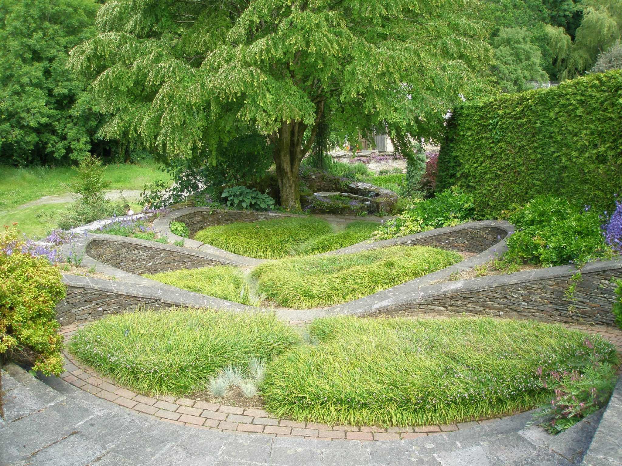 From the western end of the Bowling Green Terrace one first passes through a rustic summerhouse, which opens onto this extraordinary cascade of steps, ramps and raised beds: called THE OVAL GARDEN.