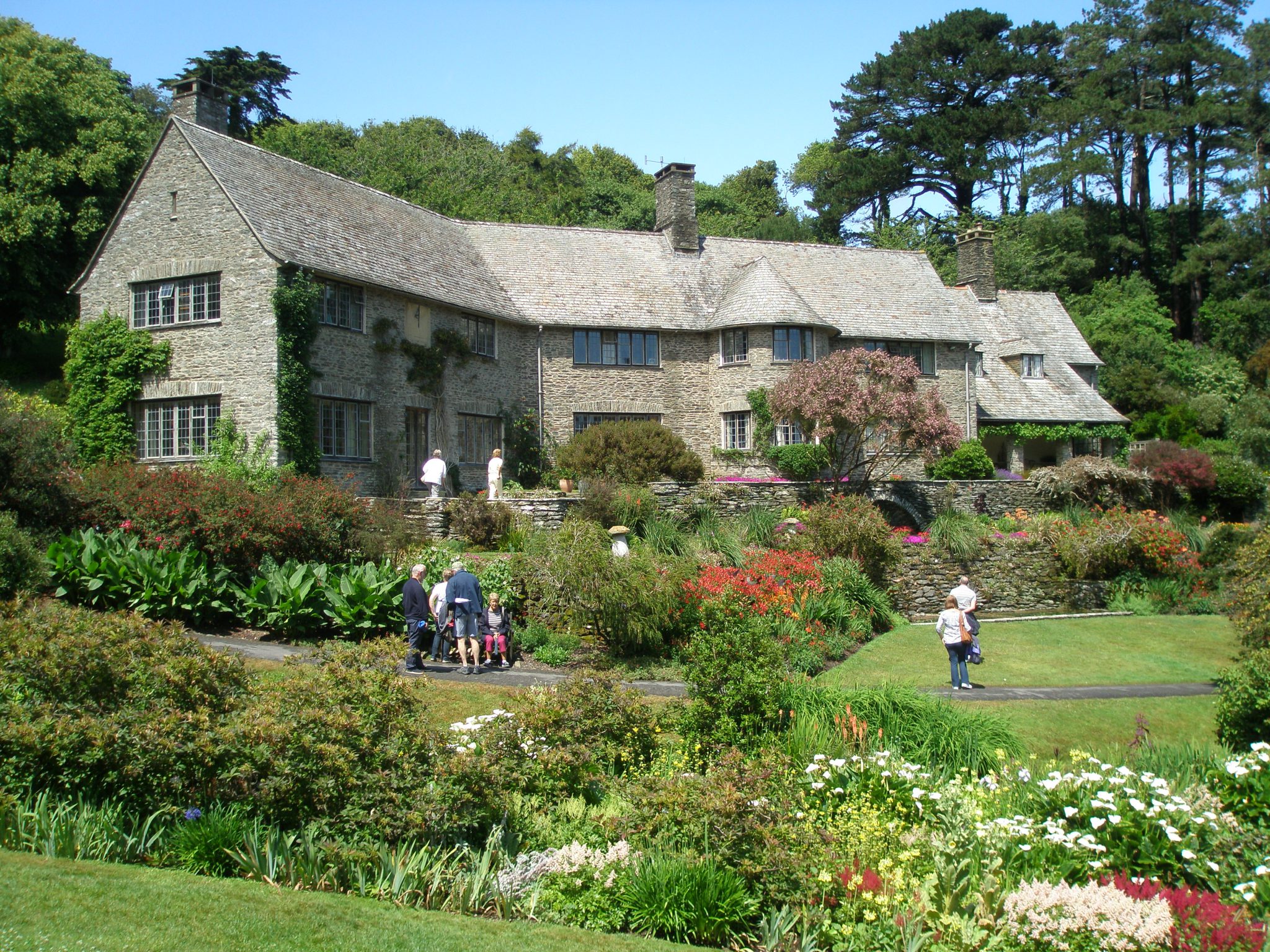  At Coleton Fishacre, by Pudcombe Cove, on the South Devon coast, we see a perfect, harmonious interplay of architecture and gardens and the greater landscape. The country retreat of Rupert and Lady Dorothy D’Oyly Carte began to be created in 1923. Rupert, the son of impresario Richard D’Oyly Carte, was the manager of the hugely popular—and profitable—Gilbert & Sullivan empire of operettas, as well as the owner of the Savoy Hotel and Claridge’s, in London. The Arts and Crafts-styled stone house and terraces were constructed largely from Dartmouth shale, which was quarried on site. On July 2nd, 2015, after a morning of dense fog and driving rain, the skies cleared, and Coleton Fishacre, which during the first hours of my visit had seemed to be a spooky Daphne-DuMaurier-setting-made-real, was transformed into the glistening, cheer-inducing, jewel-by-the-sea that you see here, and which we will explore at length, in the final portion of this Travel Diary.