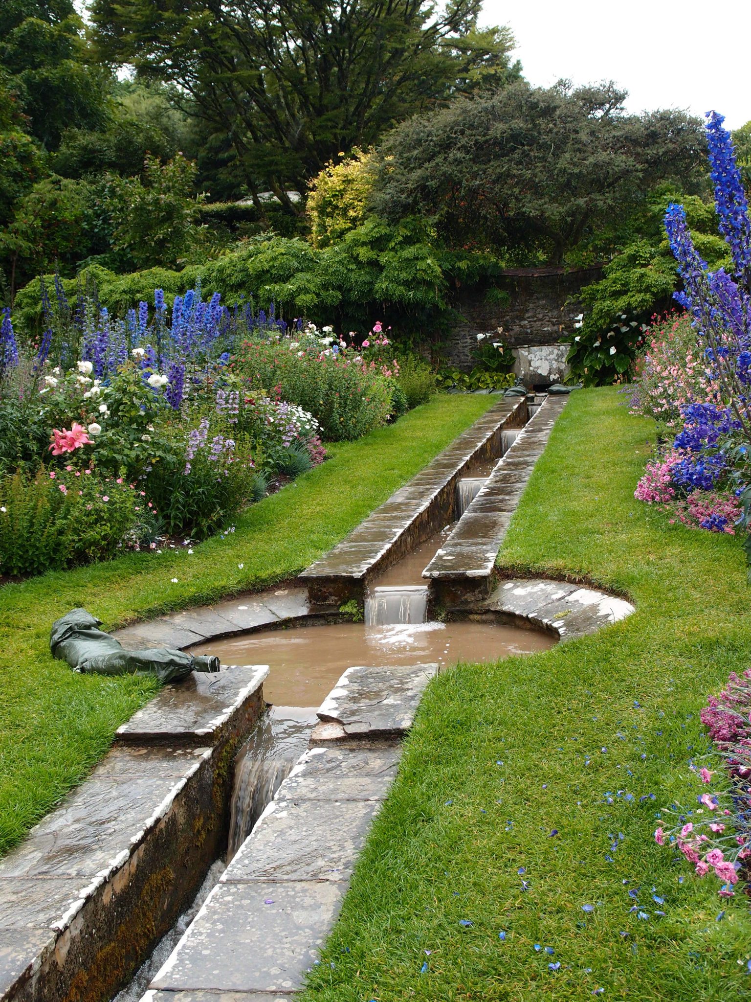  The Rill Garden was designed by Oswald Milne. This hillside garden is bisected by a narrow, canalized stream and a small, central pool. Lady Dorothy originally planted many pastel-colored rose bushes here, but those shrubs failed, in the seaside air. Semi-tender perennials now fill the Rill Garden. 